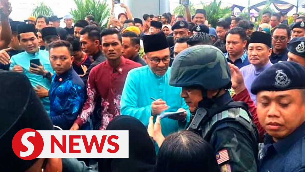 Anwar signs autographs, meets with visitors at Madani Raya event in ...